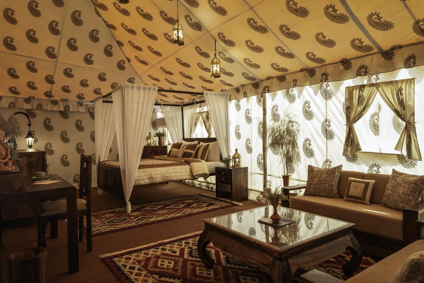 Luxury tent interior with four-poster bed and paisley-print canopy at Rann Utsav tent city